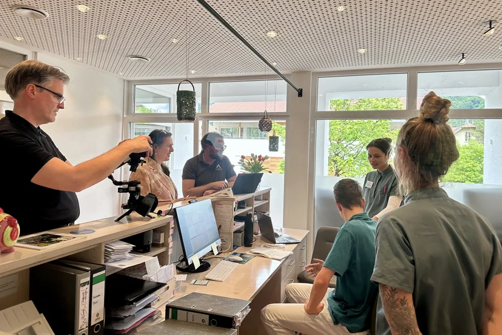 Jemand filmt an der Rezeption einer Arztpraxis das Team bei der Arbeit.